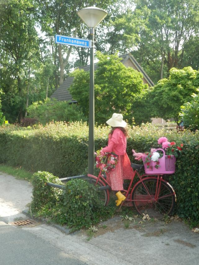 Een kleurig geklede vrouw op een fiets.