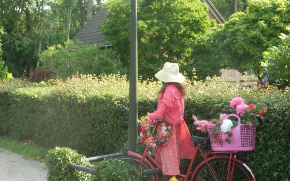 Een kleurig geklede vrouw op een fiets.