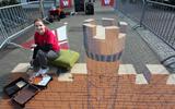 Street art kunstenaar Rianne te Kaat maakte maandag en dinsdag een kunstwerk op het Centrumplein van Wolvega.