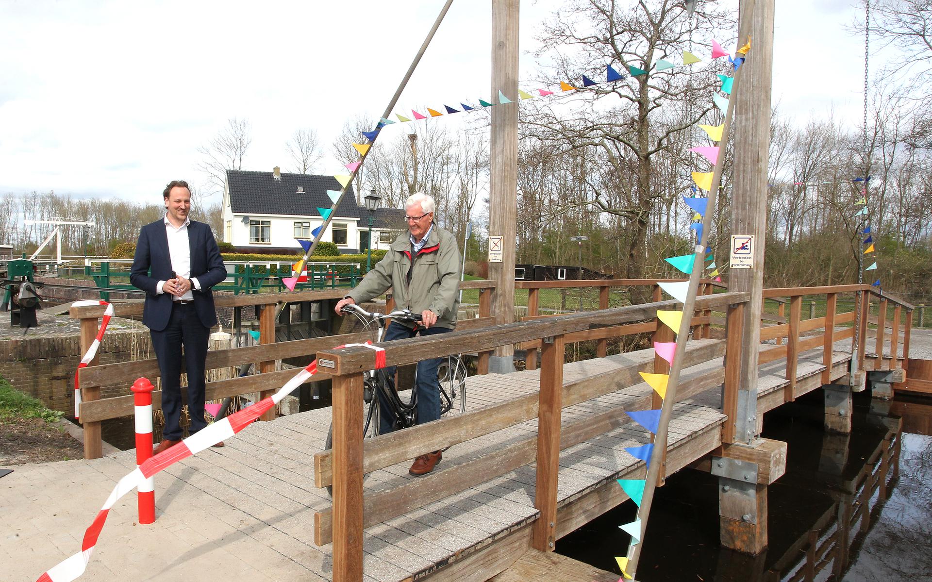 Wethouder Roelof Theun Hoen verricht de openingshandeling. De eerste fietser maakt direct gebruik van de brug.
