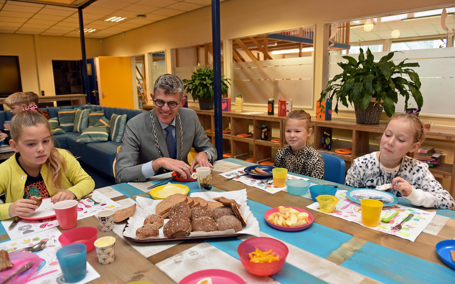 Burgemeester André van de Nadort eet een broodje mee tijdens het Nationaal Schoolontbijt.
