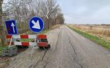 De weg vertoont door verzakkingen vele scheuren.
