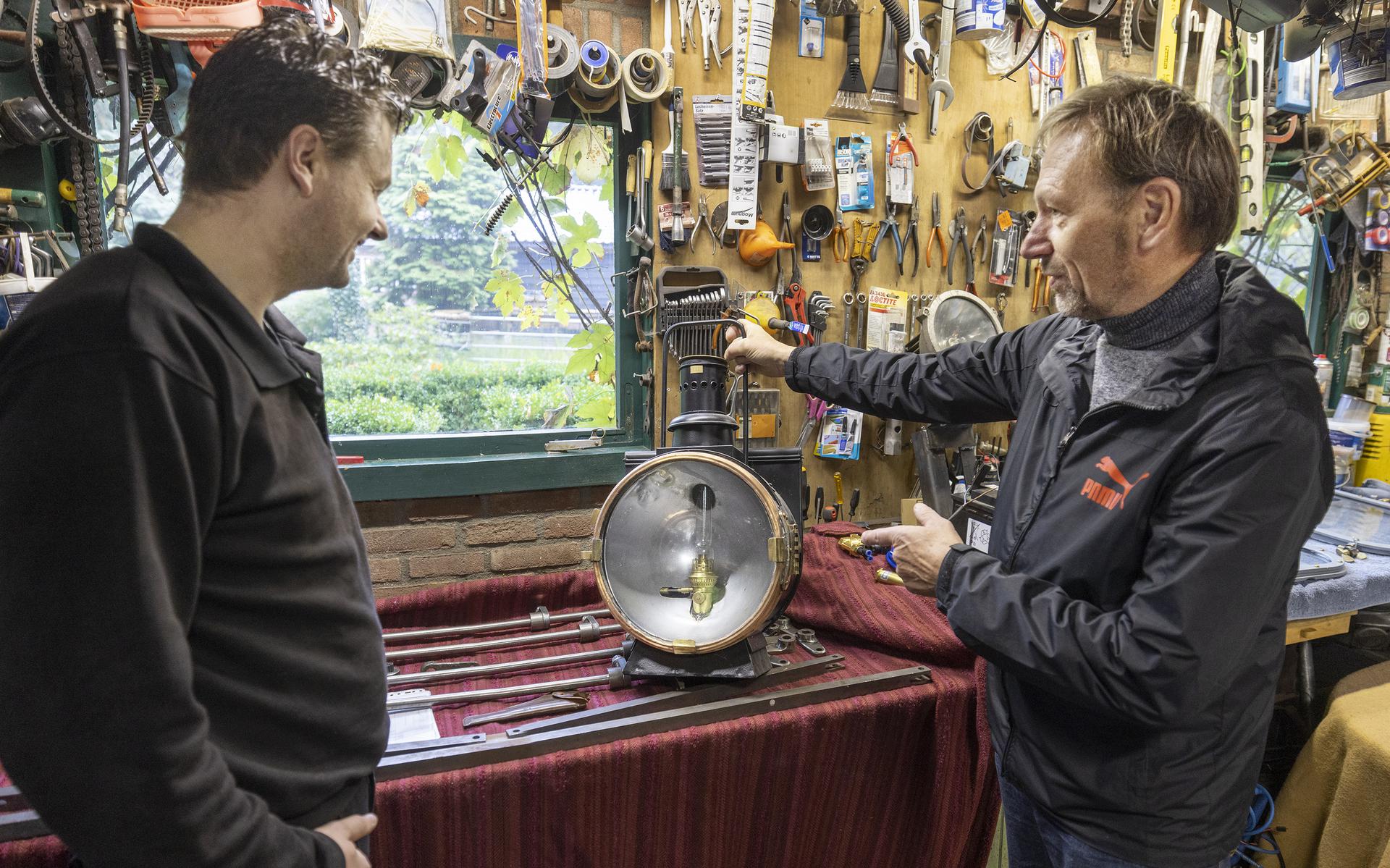 Marco Klaibeda van STAR bekijkt met Dirk Dundas (rechts) een oude lamp van de locomotief.