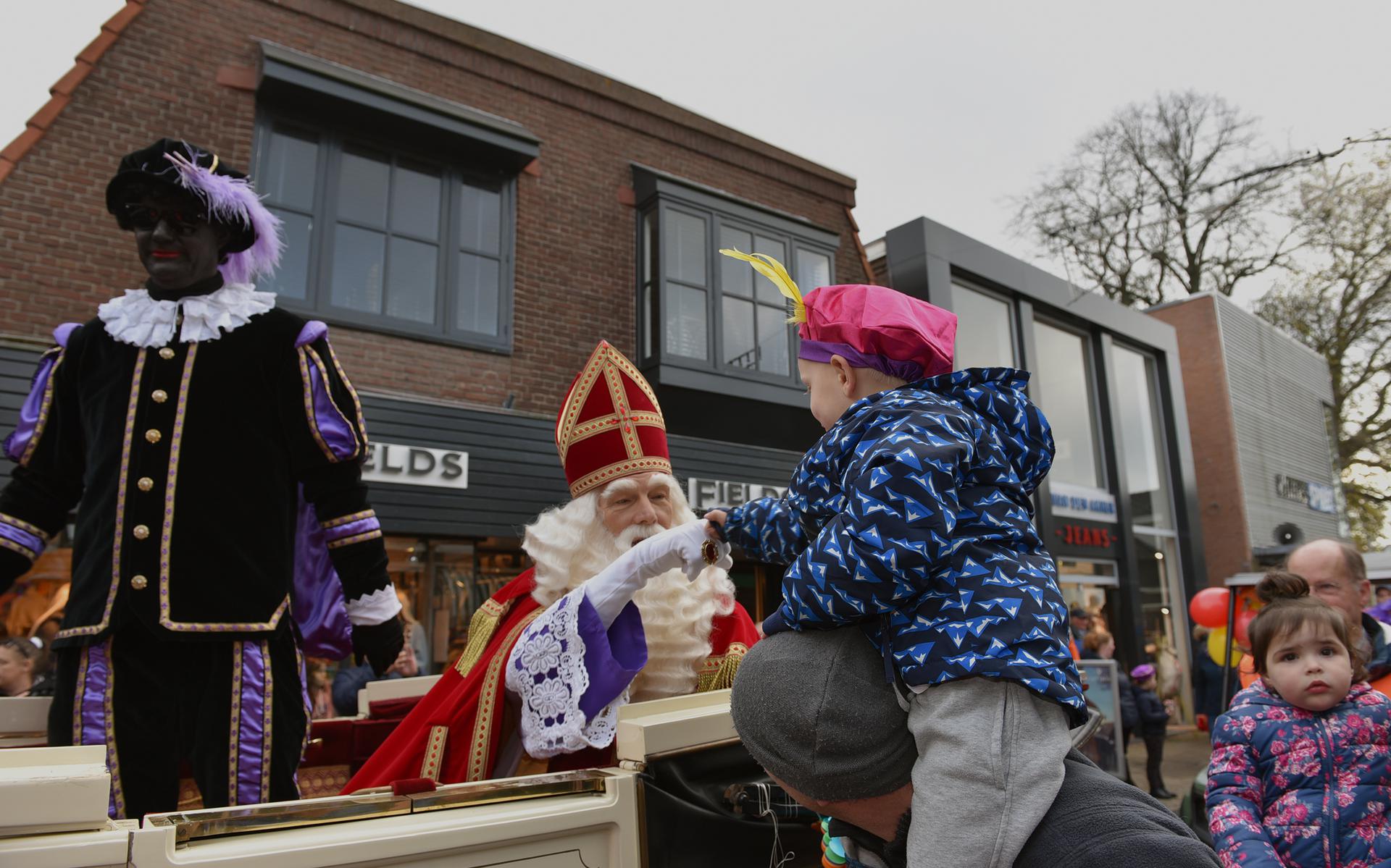  Sint en zijn Pieten reden door de winkelstraten in een rijtuig voortgetrokken door Friese paarden