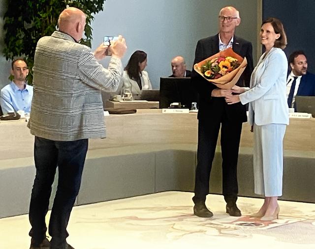 Raadslid Anton Mulder van Blijf Stellingwarfs fotografeert zijn broer Ton Mulder, die na het afleggen van de belofte een bloemetje krijgt van burgemeester Stieneke van der Graaf.