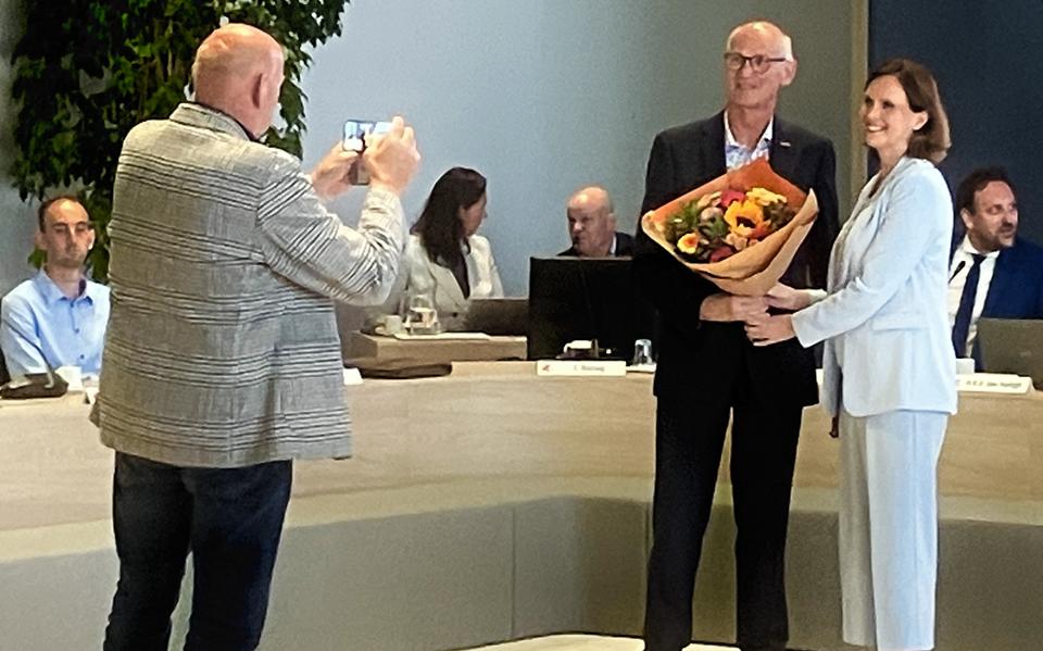 Raadslid Anton Mulder van Blijf Stellingwarfs fotografeert zijn broer Ton Mulder, die na het afleggen van de belofte een bloemetje krijgt van burgemeester Stieneke van der Graaf.
