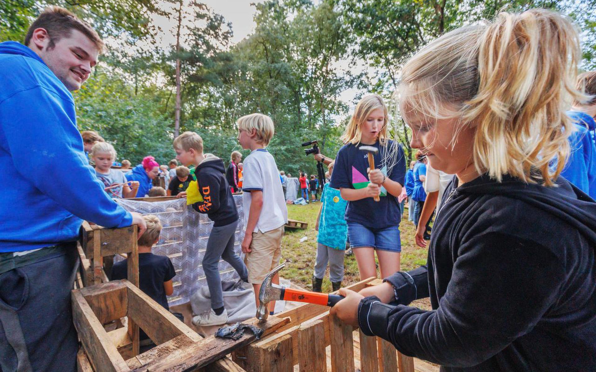 Kinderen bouwen hutten tijdens Speelland.