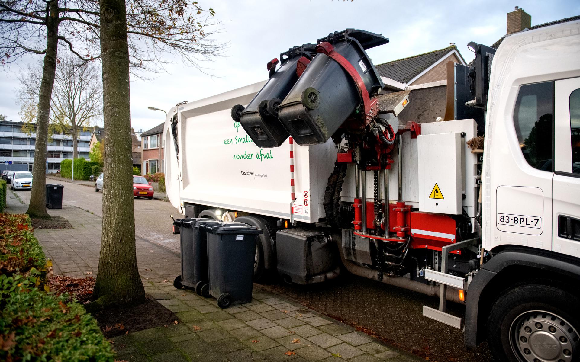Een vuilniswagen van de gemeente Smallingerland halt de containers met restaval op aan de Veenscheiding in Drachten. 