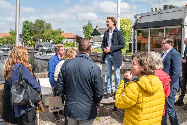 Wethouder Melvin Smit (BGL) staat de Statenleden te woord in Ossenzijl, tijdens een werkbezoek in mei.